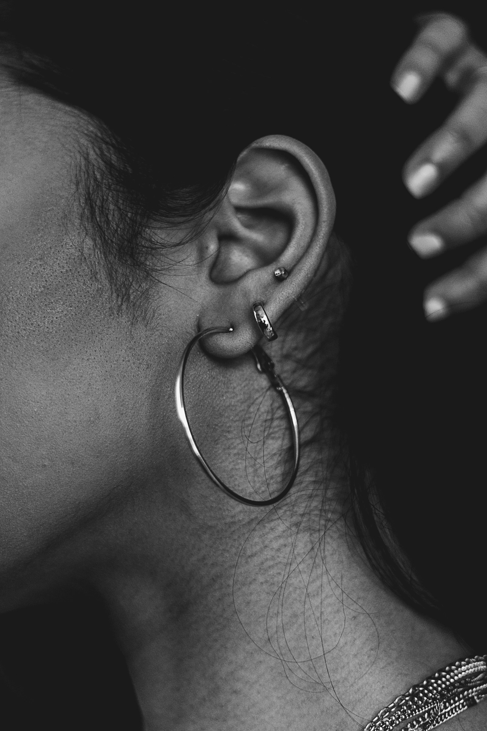A close view of an ear with several jewelry placements