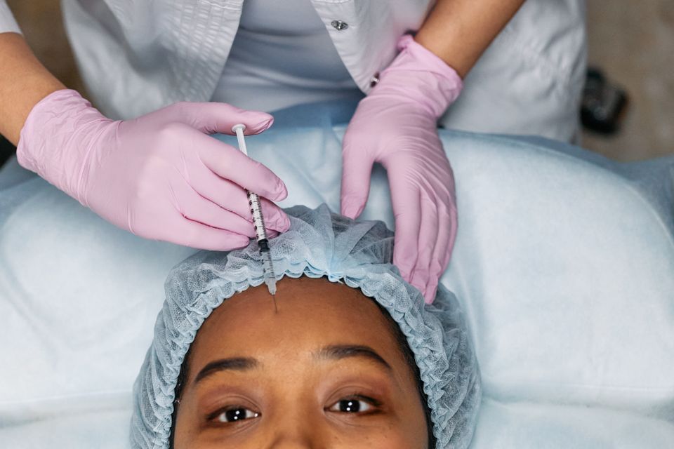 Forehead treatment with gloved hands